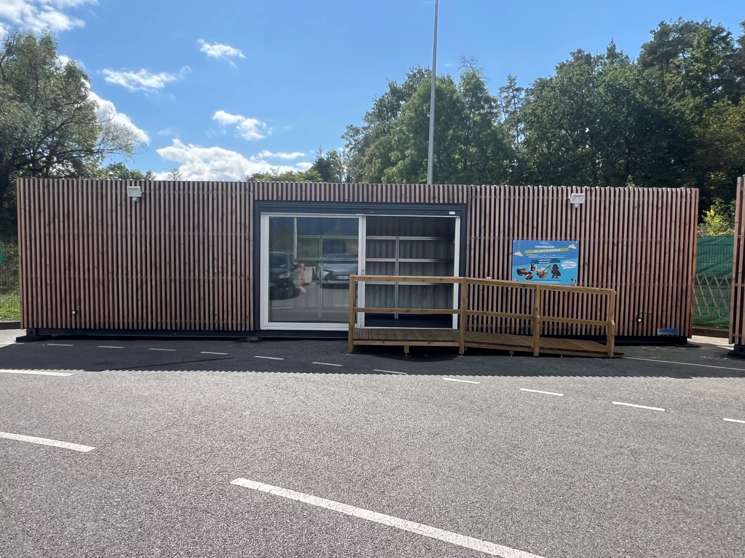 Conteneur RecyKlerie aménagé avec bardage bois et rampe d’accès PMR, installé en extérieur.